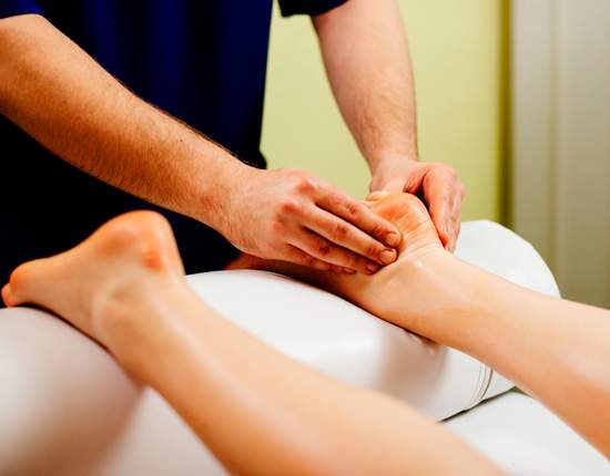 Masajista aplicando reflexología podal en domicilio en Lanzarote con técnica profesional